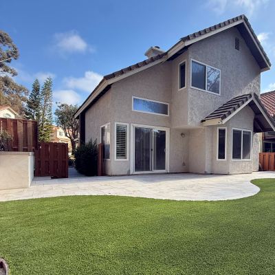 Finished backyard with a curved concrete patio and artificial turf, Carlsbad
