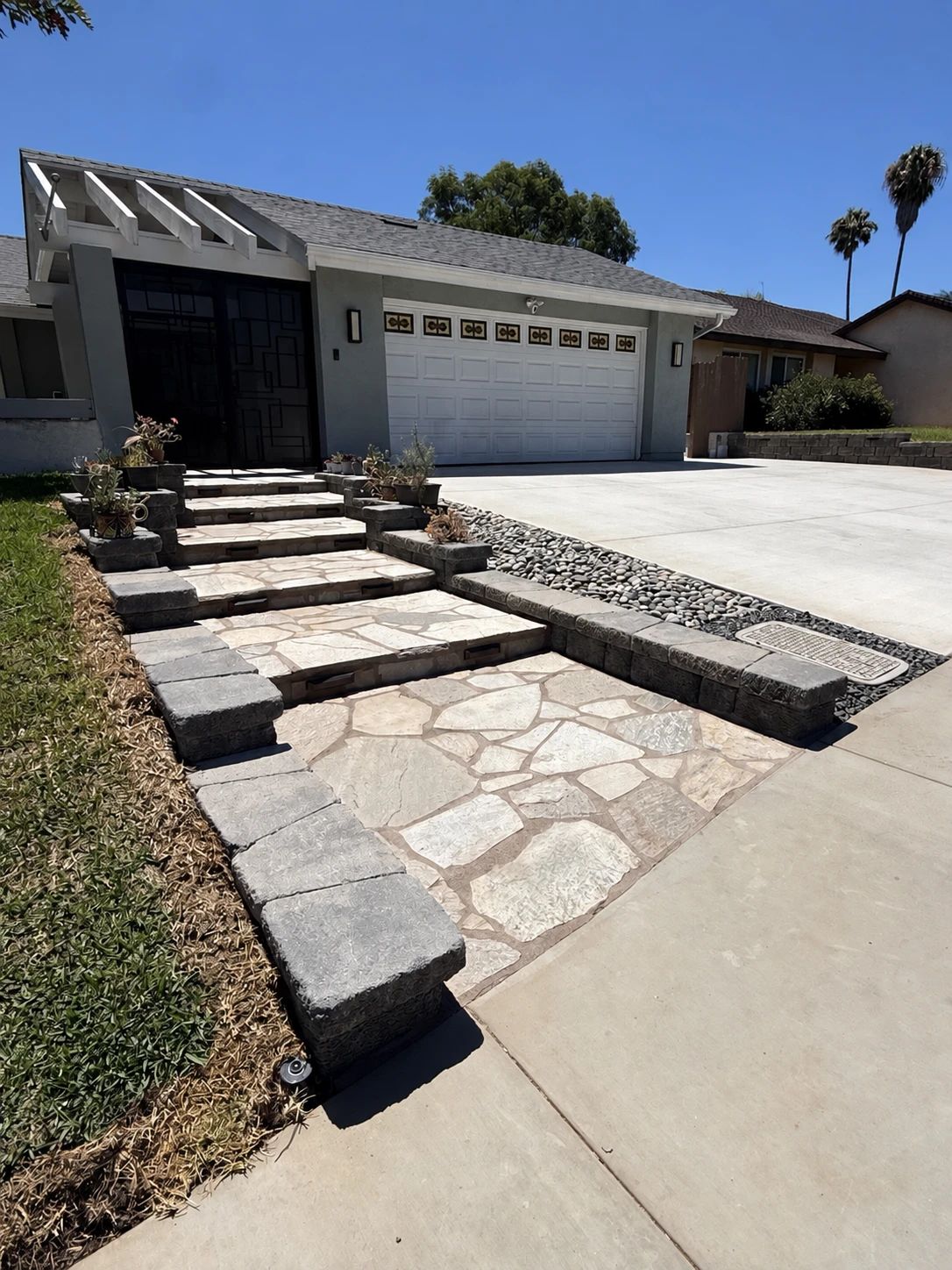 Completed natural quartzite entry steps with illuminated retaining and cheek walls in San Marcos