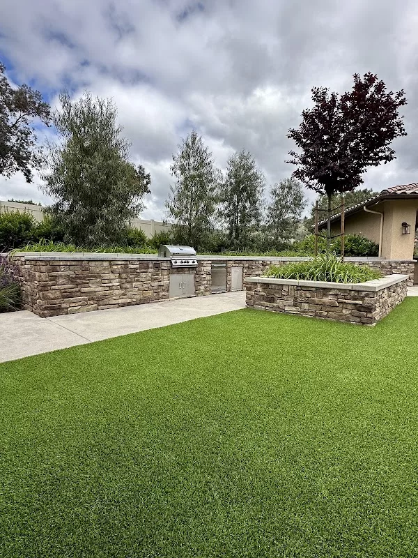 Artificial turf and stone veneer outdoor living area with built-in BBQ in Ramona, CA