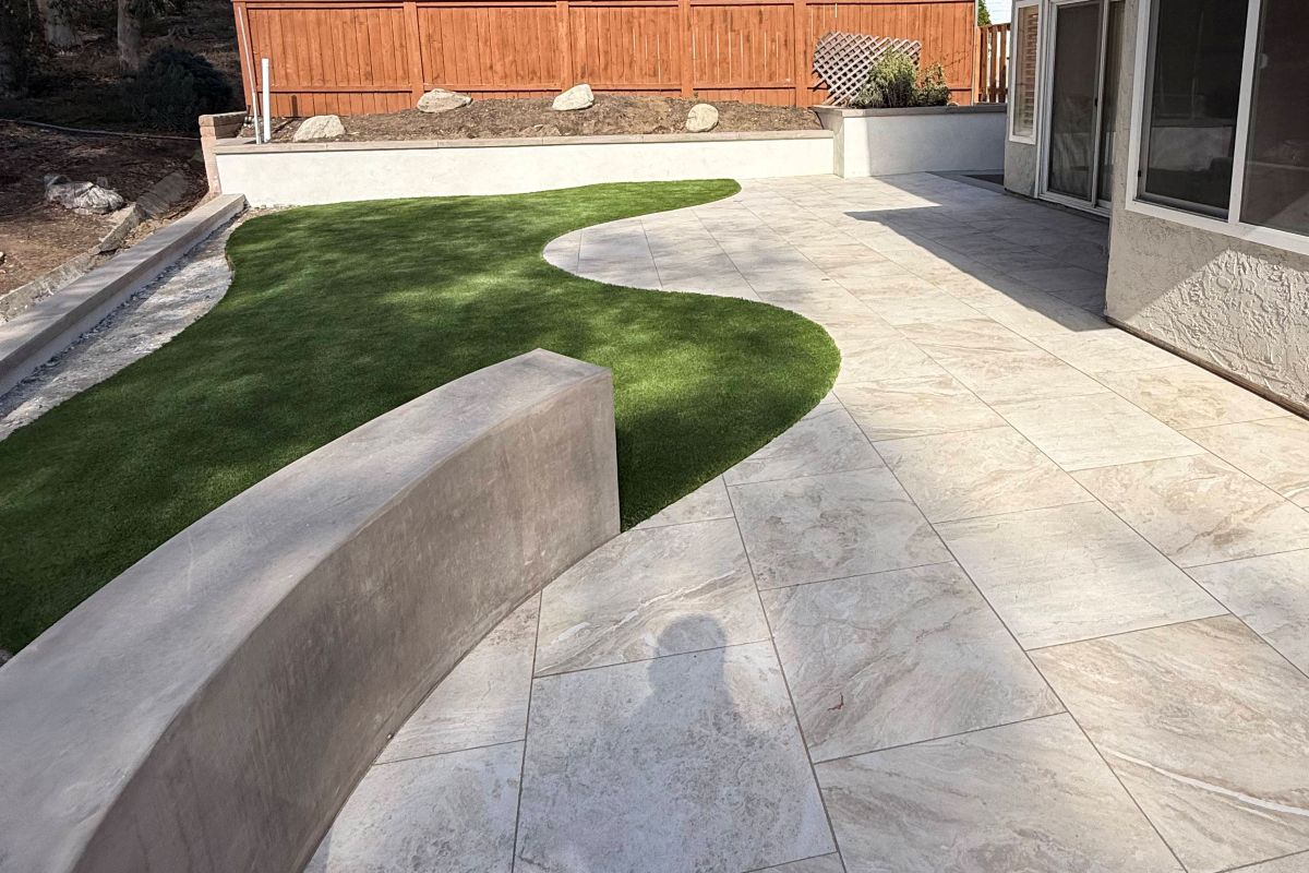 Completed backyard with concrete patio, curved wall and artificial turf, Carlsbad