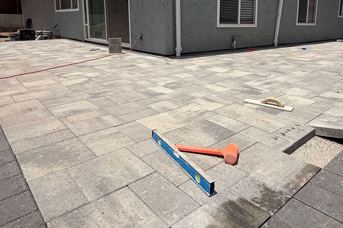 Paver patio installation along the back of a home, San Marcos