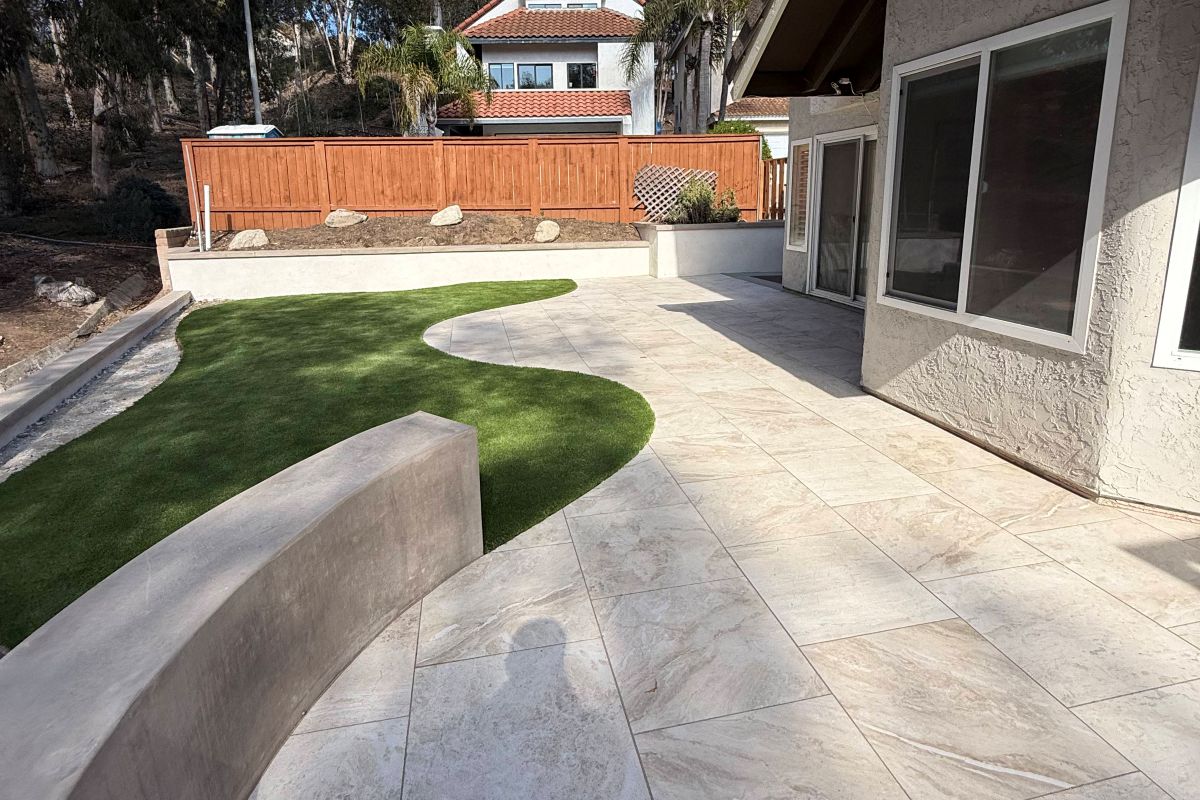 Curved retaining wall beside a concrete patio and artificial turf, Carlsbad